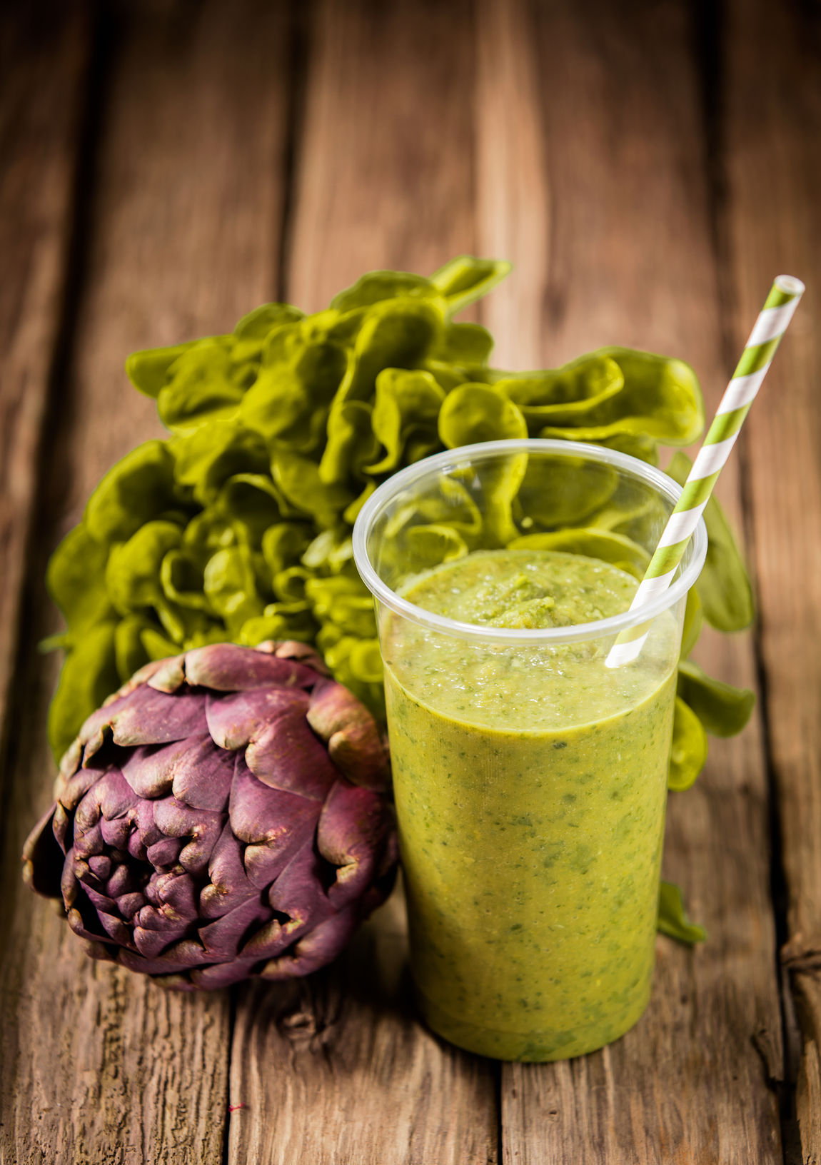 27128990 - healthy vegetarian artichoke and lettuce smoothie with fresh ingredients on an old rustic wooden kitchen table