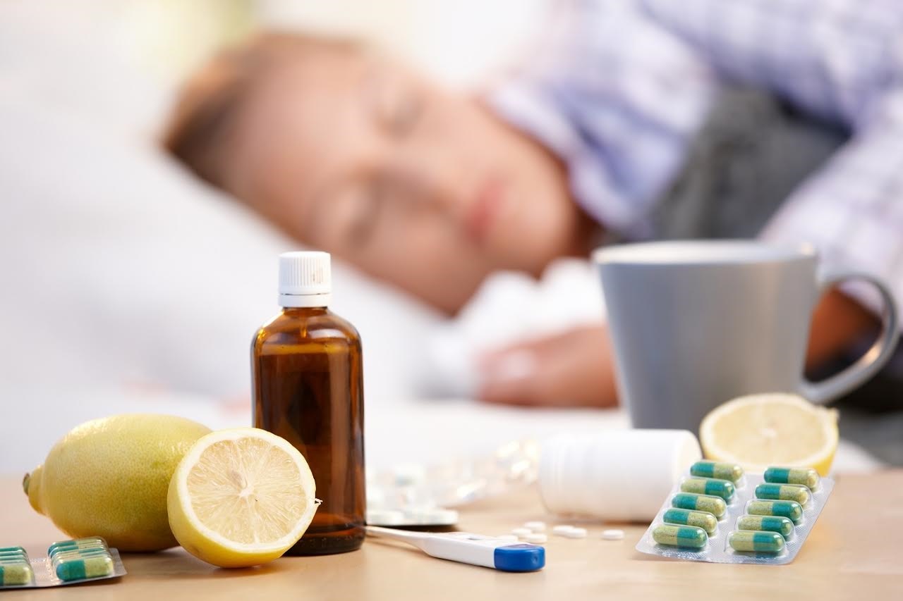 Vitamins, medicines and hot tea in front, woman caught cold sleeping in background.?; Shutterstock ID 64485970; PO: 10047953; Other: Public Affairs